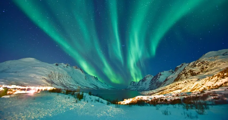 A bright green aurora over a snowy landscape