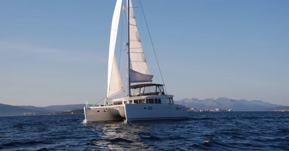 A sailing catamaran on a calm fjord near Tromsø in winter light